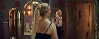 a woman in a black dress brushing her hair