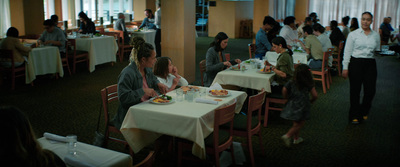 a group of people sitting at tables in a restaurant