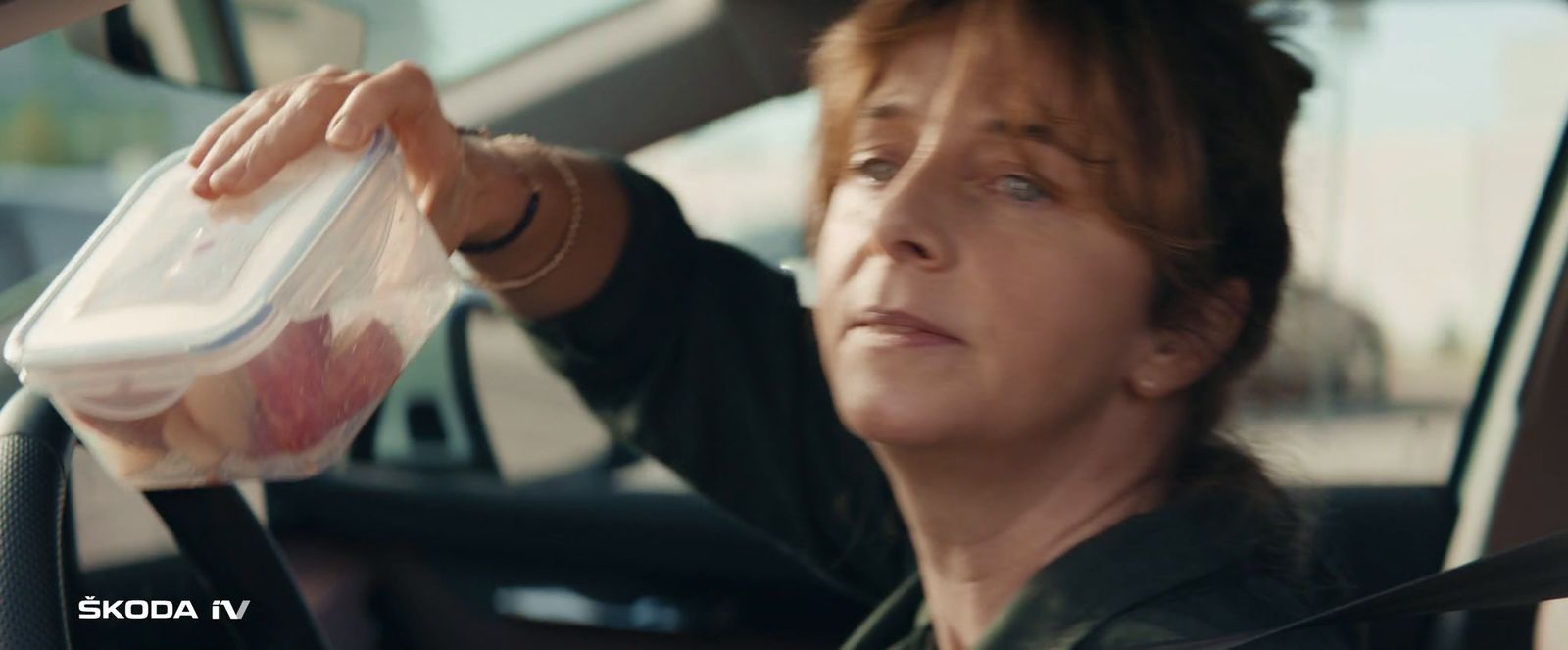 a woman in a car holding a plastic container