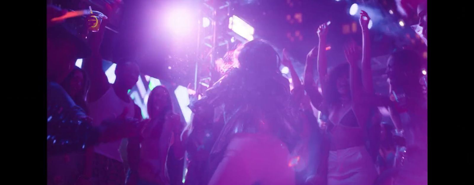 a woman standing in front of a purple light