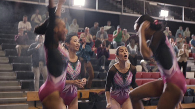 a group of cheerleaders perform in front of a crowd