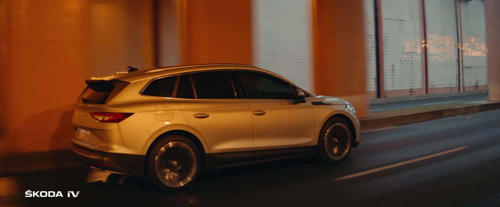 a white car driving down a street at night