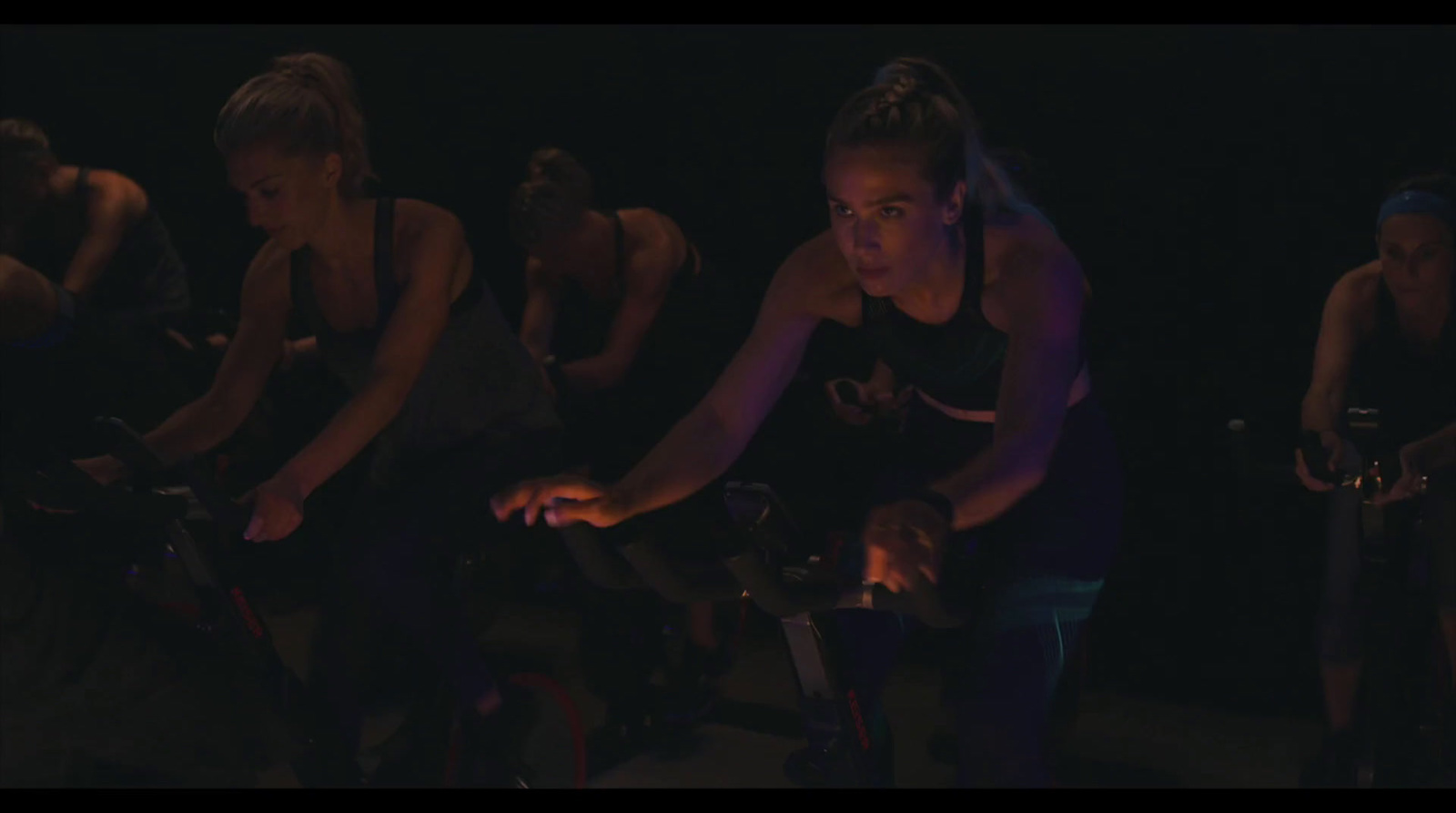 a group of women riding bikes in the dark