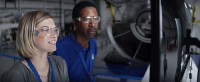 a man and a woman standing in front of a machine