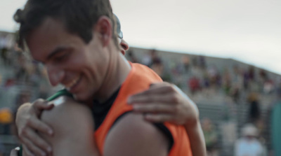 a man in an orange vest holding a woman