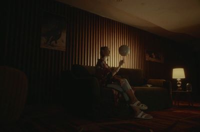 a person sitting on a couch in a dark room