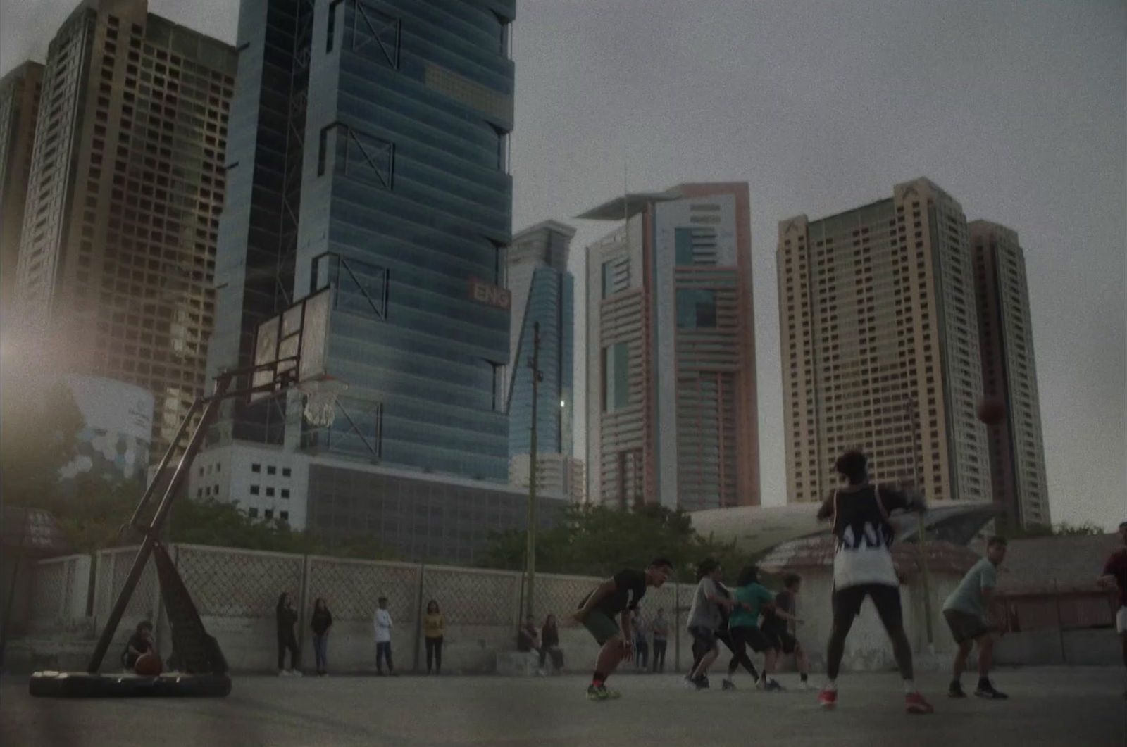 a group of people standing around a basketball court