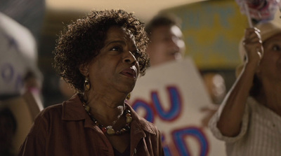 a woman holding up a sign with another woman holding a sign behind her