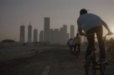 a group of people riding bikes down a dirt road