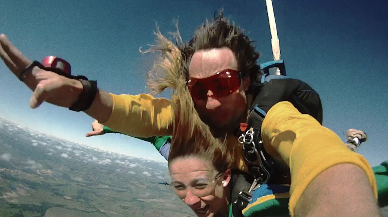 a man and a woman are paragliding in the sky