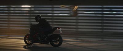 a man riding a motorcycle down a street at night