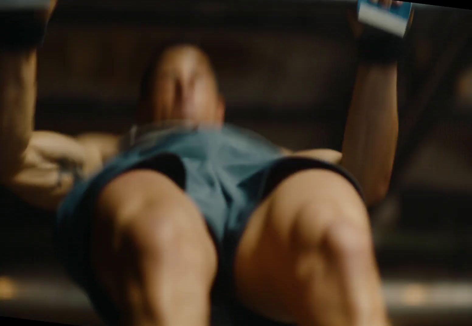 a man laying on a bench holding a pair of dumbbells