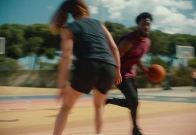 a man and a woman playing basketball on a court