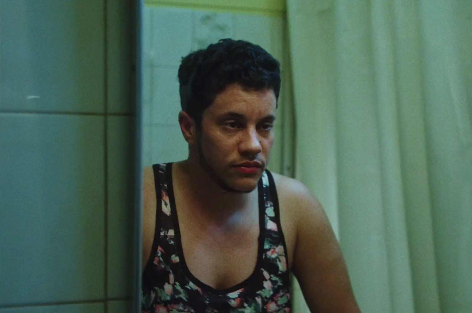 a man in a tank top standing in front of a mirror