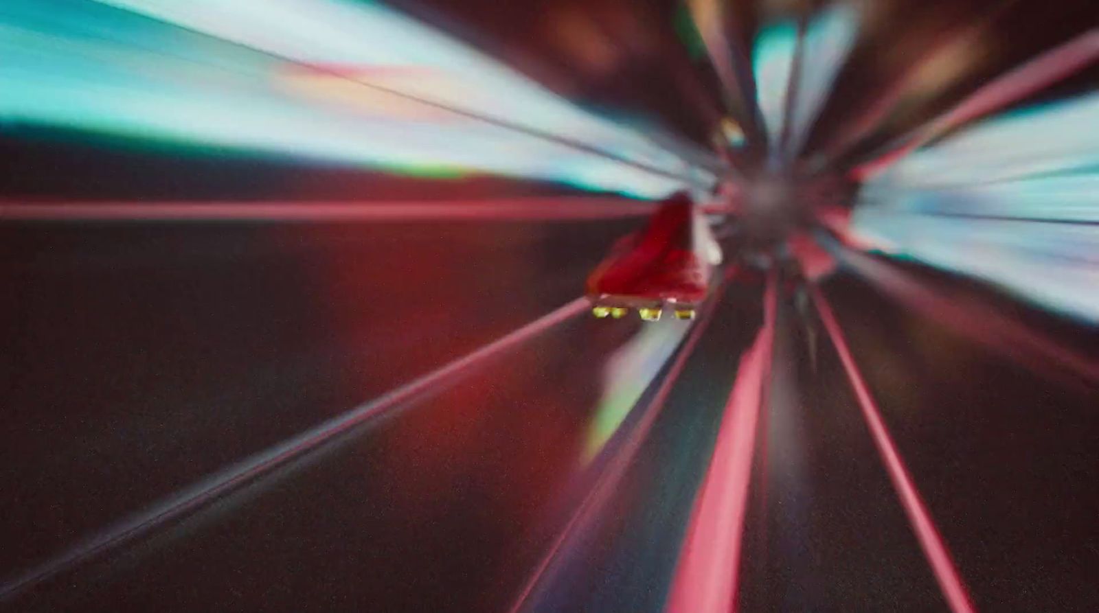 a blurry photo of a red car driving through a tunnel