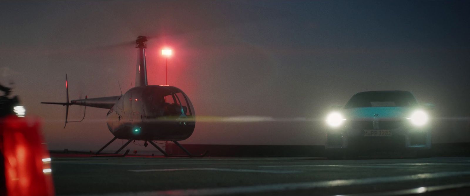 a helicopter and a car on a runway at night