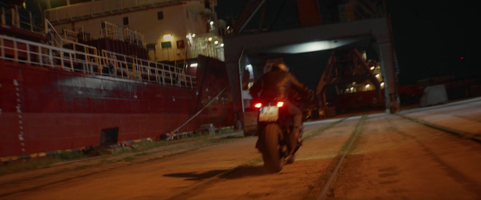 a man riding a motorcycle down a street at night