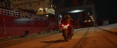 a man riding a motorcycle down a street at night