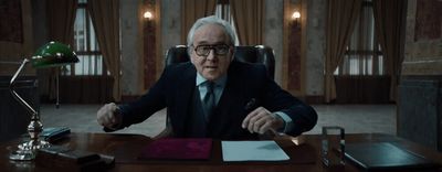 a man in a suit and tie sitting at a desk