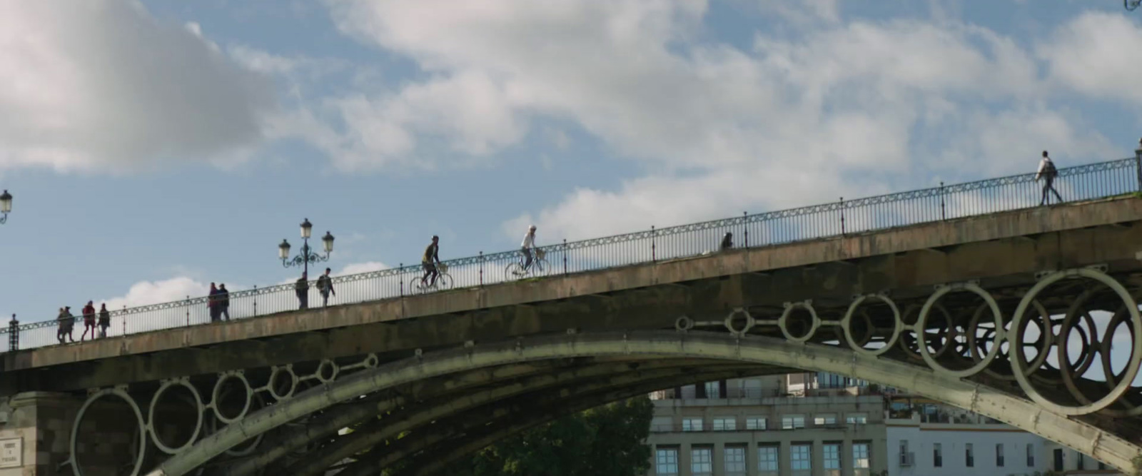 a group of people walking across a bridge