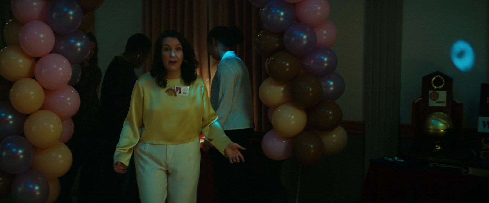 a woman standing in front of balloons in a room