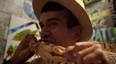 a man in a hat eating a hot dog