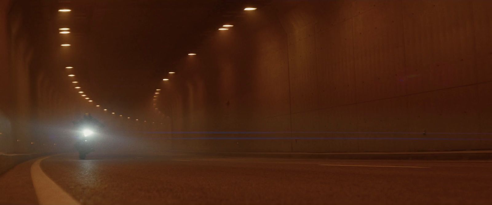 a car driving down a tunnel at night