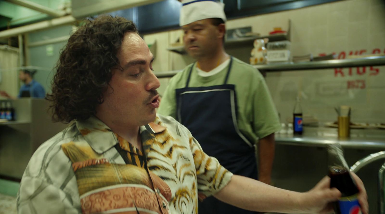 a man holding a bottle of wine in a kitchen