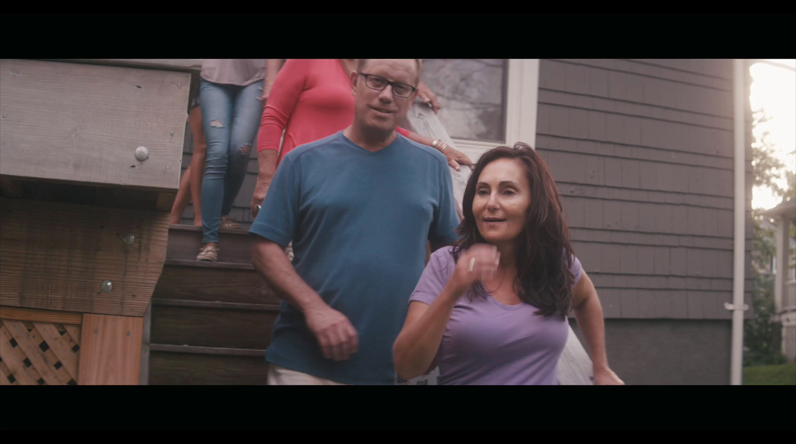 a man and a woman standing in front of a house