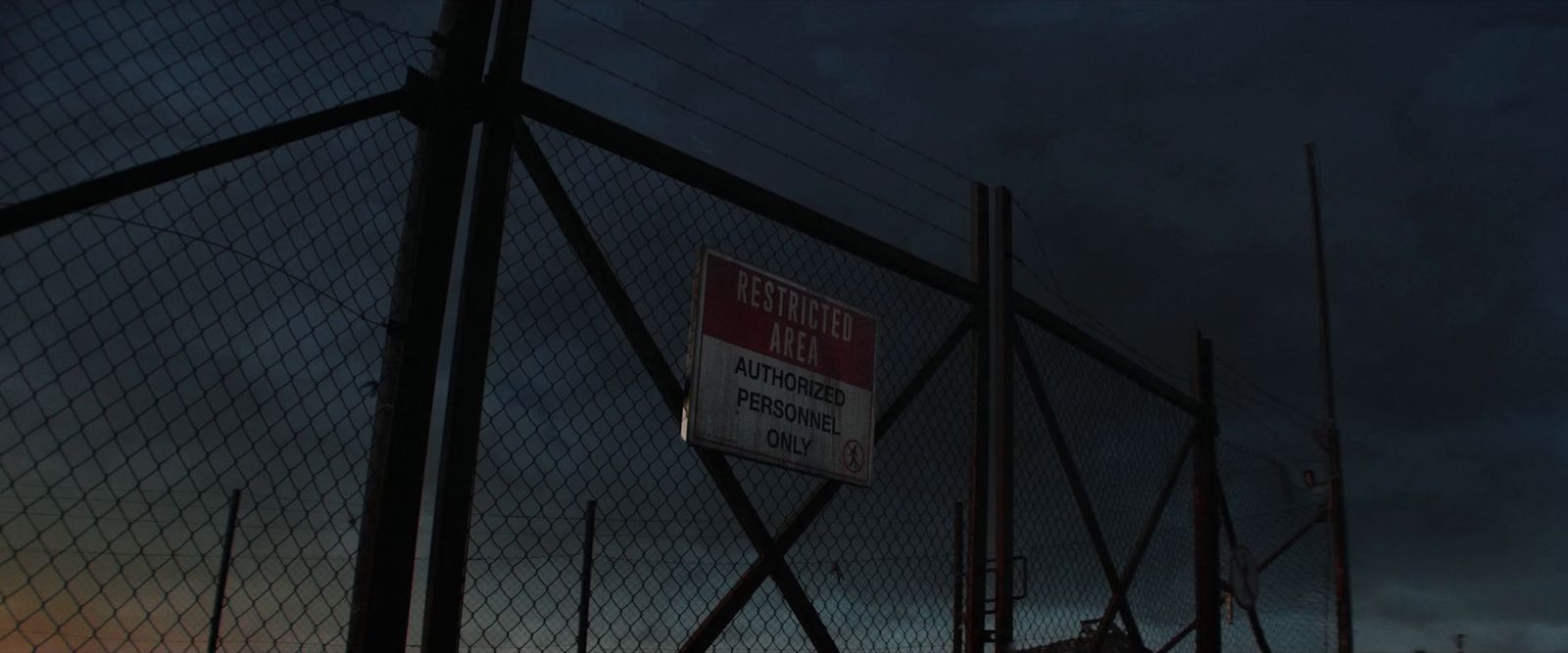 a red and white sign is on a fence