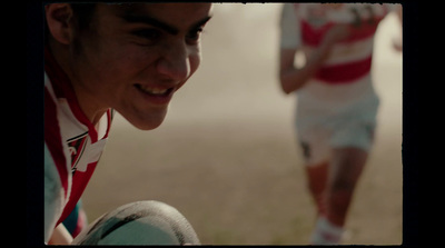 a young man in a red and white striped shirt is holding a ball