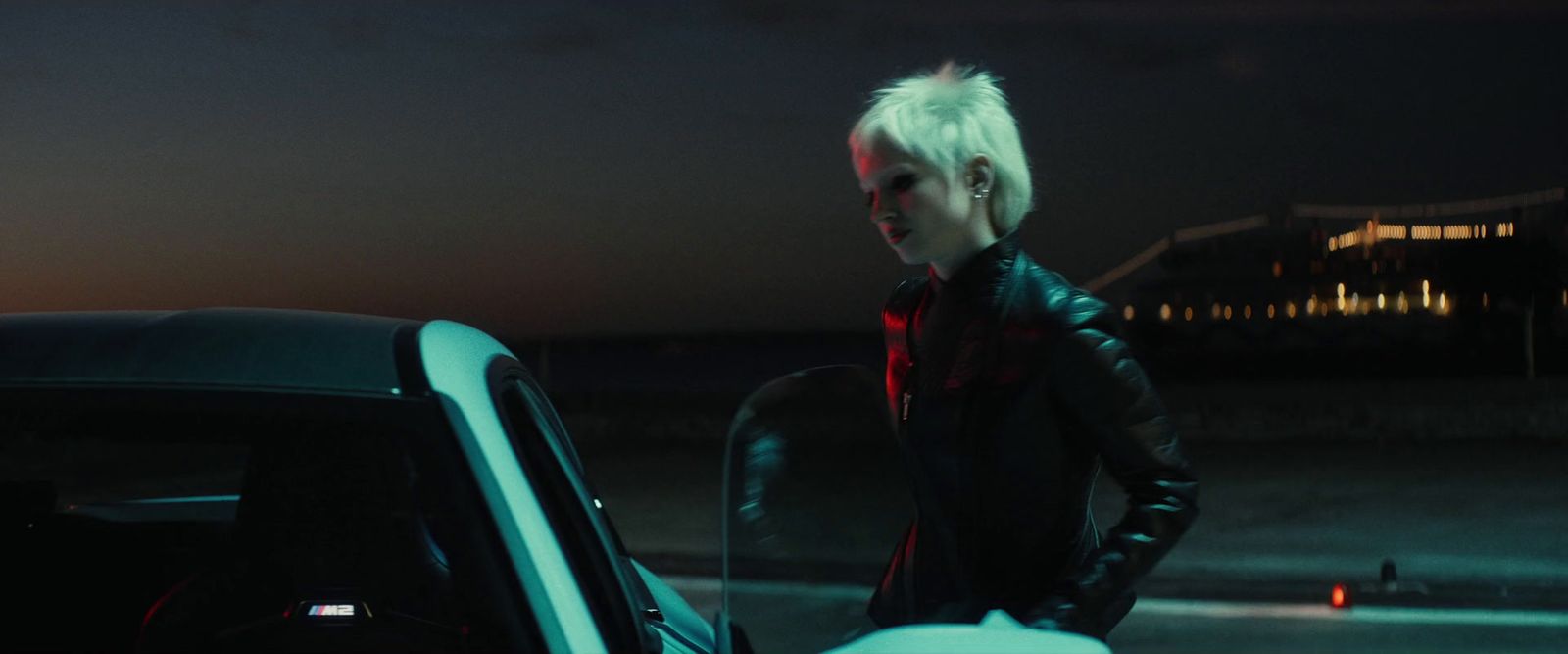 a man with white hair standing next to a car