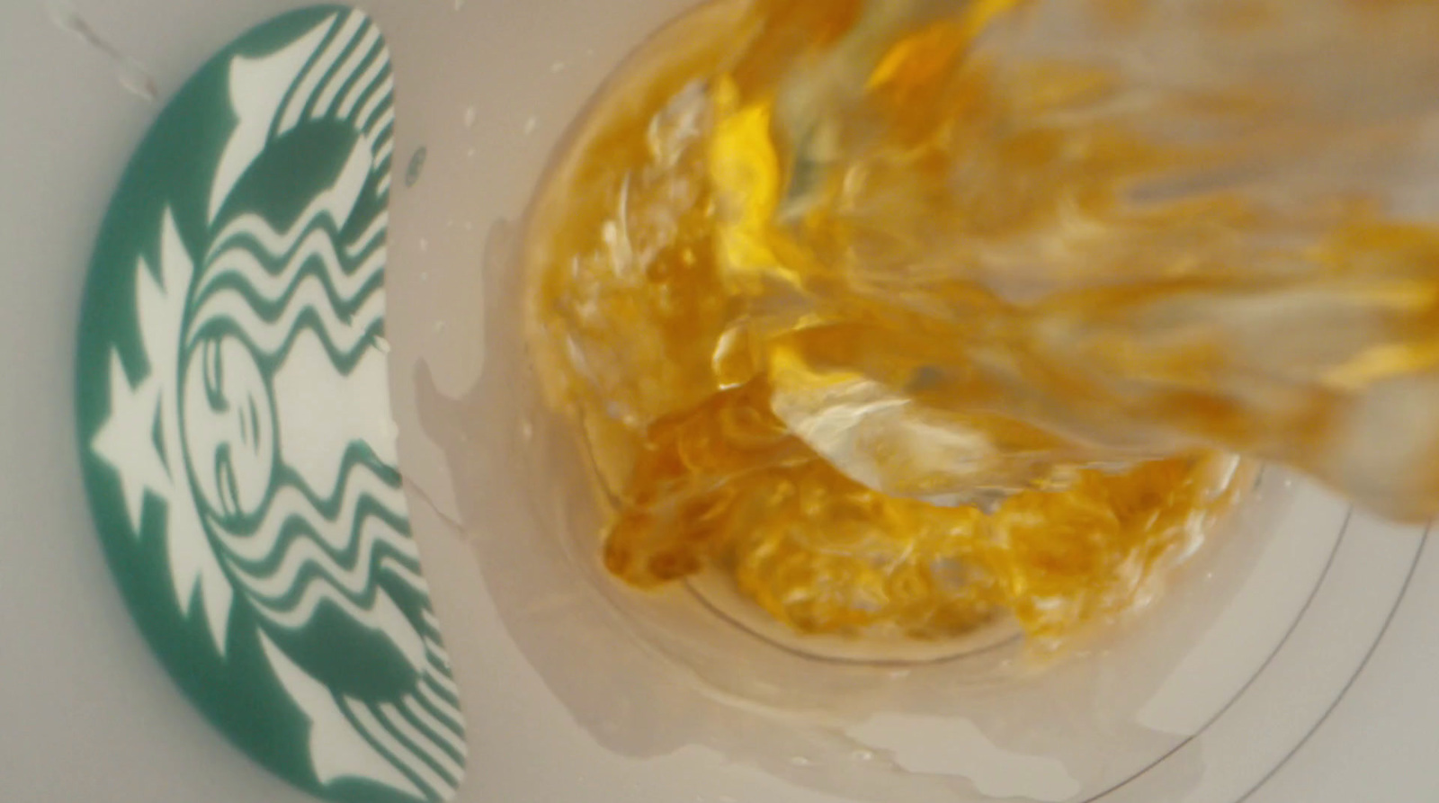 starbucks pouring liquid into a cup