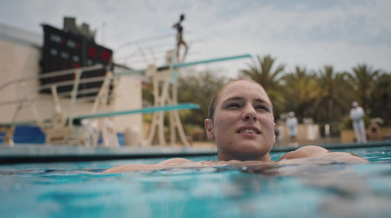 a woman swimming in a pool next to a boat