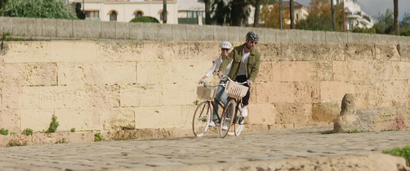 a couple of people riding bikes down a street