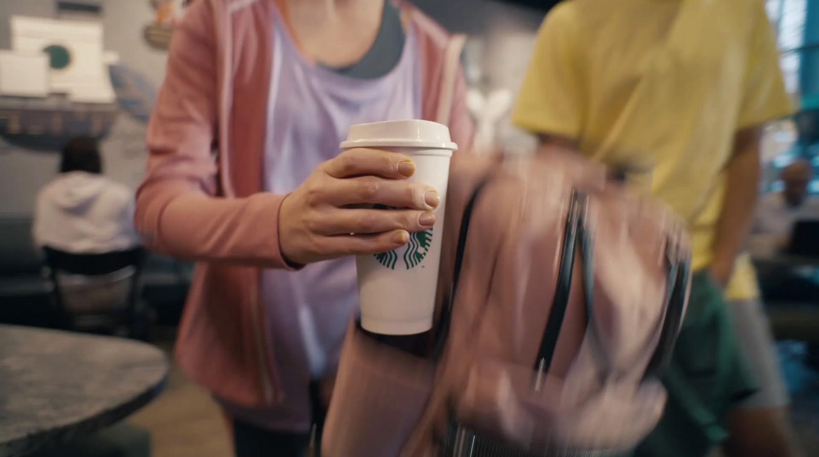 a woman holding a cup of coffee in a coffee shop