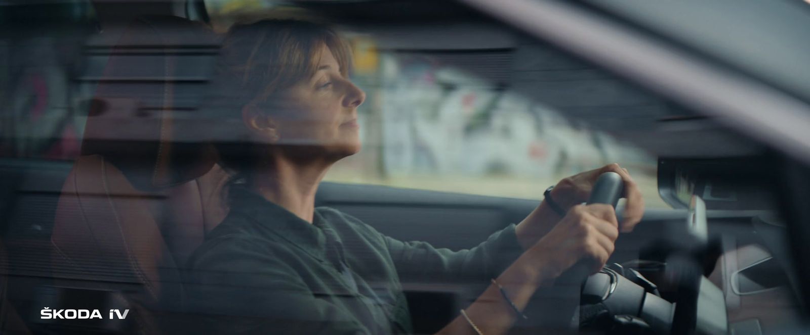 a woman sitting in a car holding a steering wheel