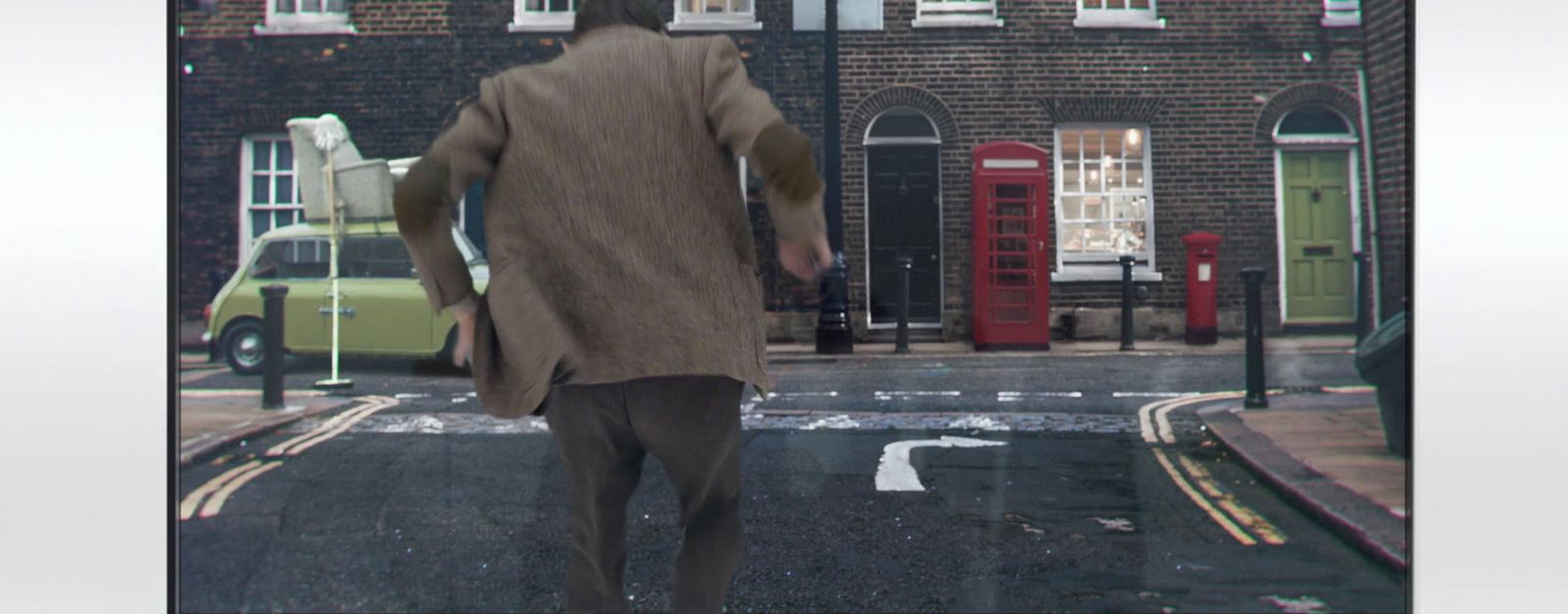 a man is walking down the street in the rain