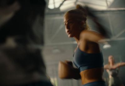 a woman in a blue sports bra top is dancing