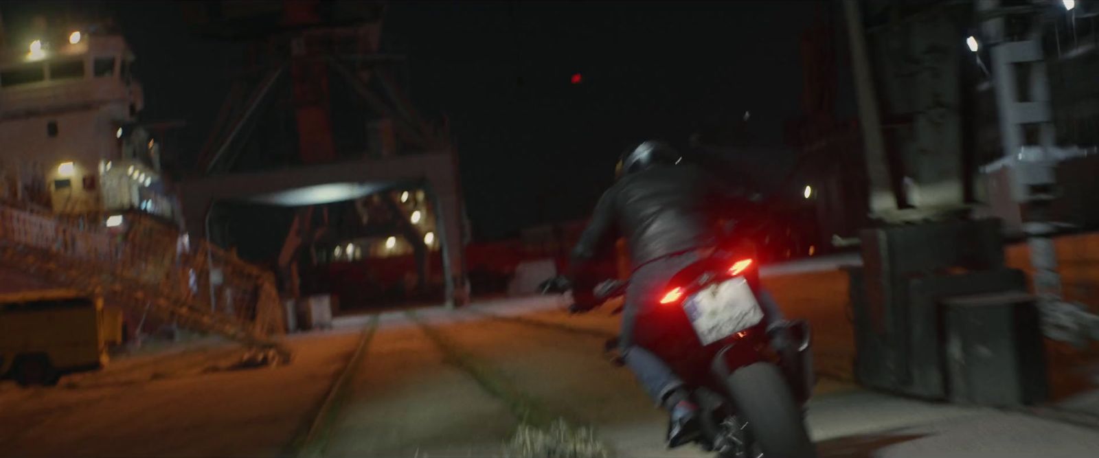 a man riding a motorcycle down a street at night