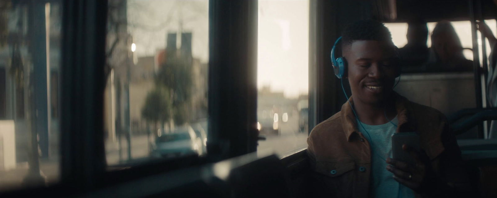 a man with headphones on standing in front of a bus