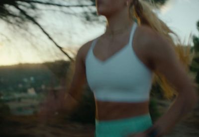 a woman in a white tank top and green shorts