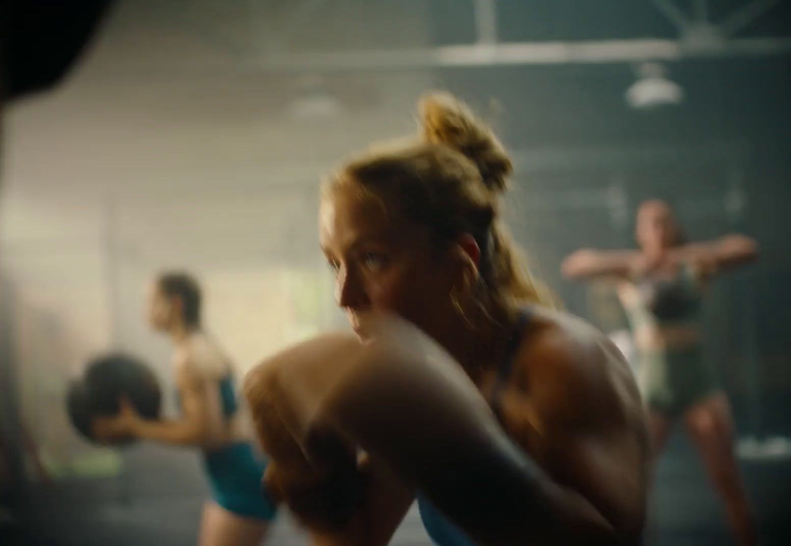 a group of women in a gym with a punching bag