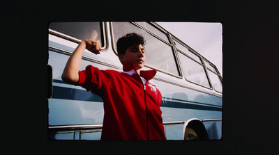 a young man is standing in front of a bus