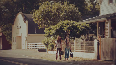 three women walking down the street with luggage