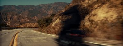 a blurry photo of a car driving down a mountain road