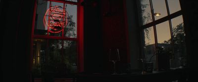 a red neon sign in the window of a restaurant