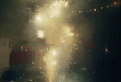 a group of people watching fireworks in a dark room