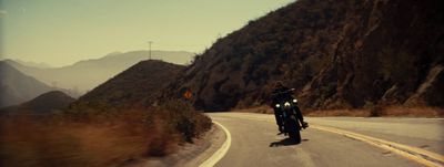 a man riding a motorcycle down a curvy road