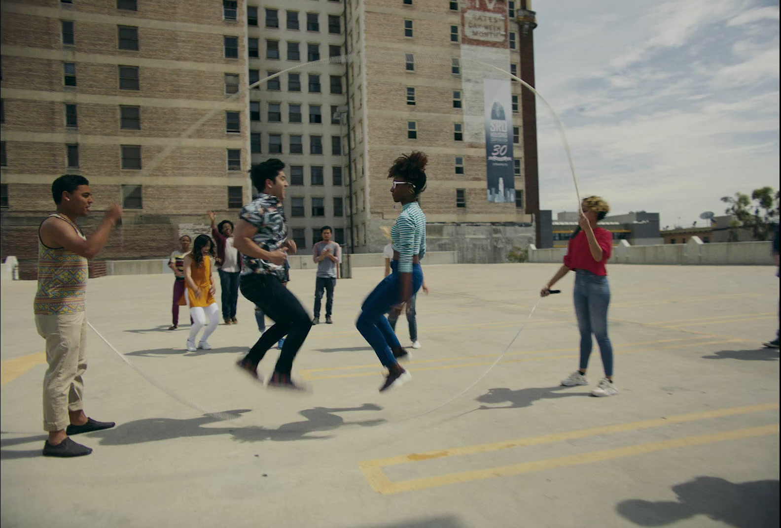 a group of people playing with a rope in a parking lot